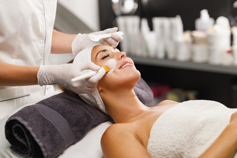 Beautiful young woman getting a facial mask treatment