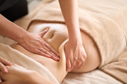 A women taking manual lymphatic drainage massage stomach