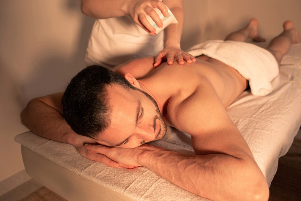 Massage therapist performing pain relief massage in a wellness clinic.