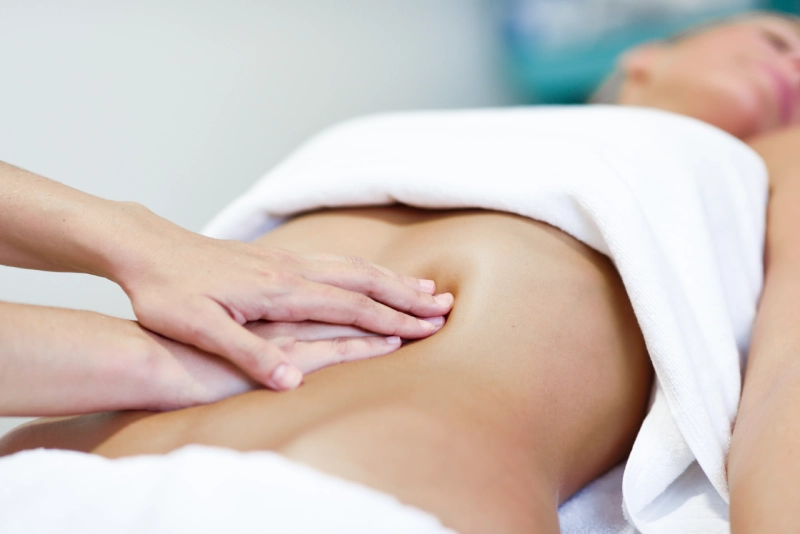 Lymphatic massage massaging female abdomen therapist applying pressure belly
